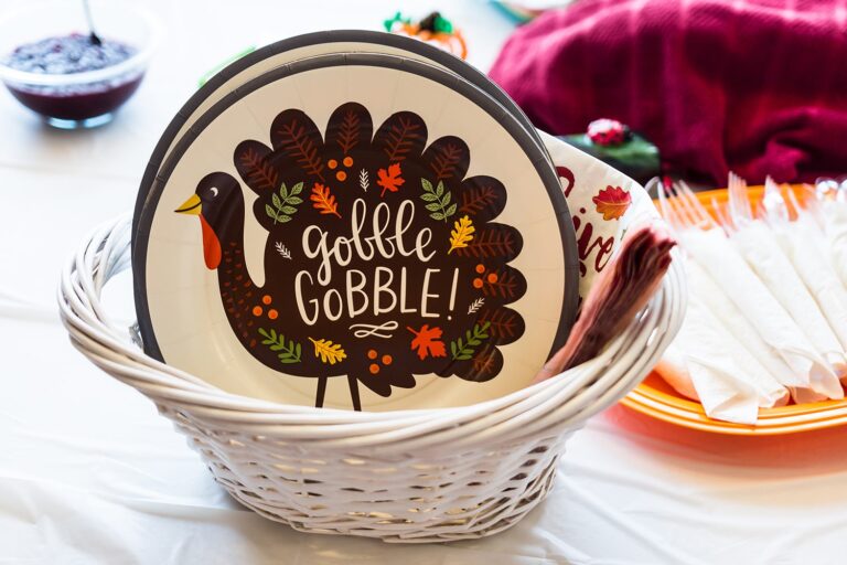 A basket of thanksgiving paper plates and napkins on table