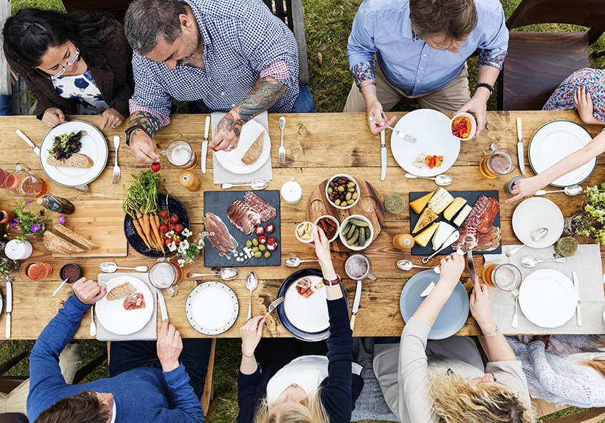 Group gathered at a picnic table sharing a meal together.