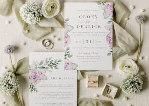 Wedding invitations with flowers and ribbons around them.