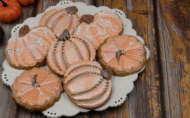 Detailed pumpkin wedding cookies on a cute white plate.